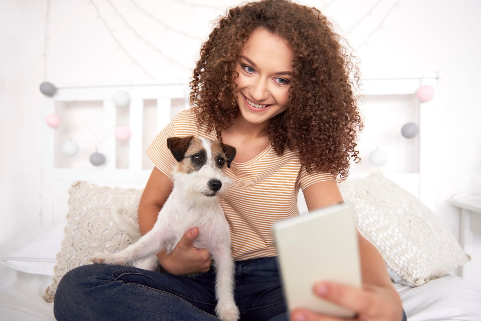 Jovem com seu cachorro usando o celular